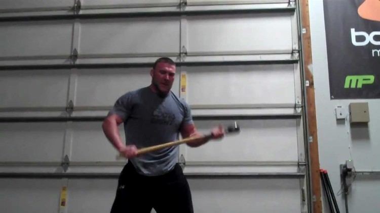 Branden Lee exercising while wearing a gray t-shirt and black pants