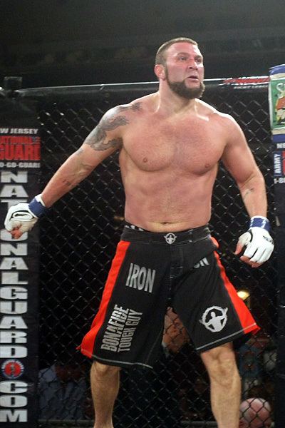 Branden Lee Hinkle in his mixed martial art fight while wearing black and red shorts and gloves