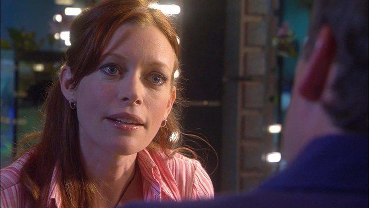 Brenda James as Dr. Katie Brown talking to a man and wearing a striped pink blouse in a scene from an adventure and military science fiction television series, Stargate: Atlantis (2005-2008).