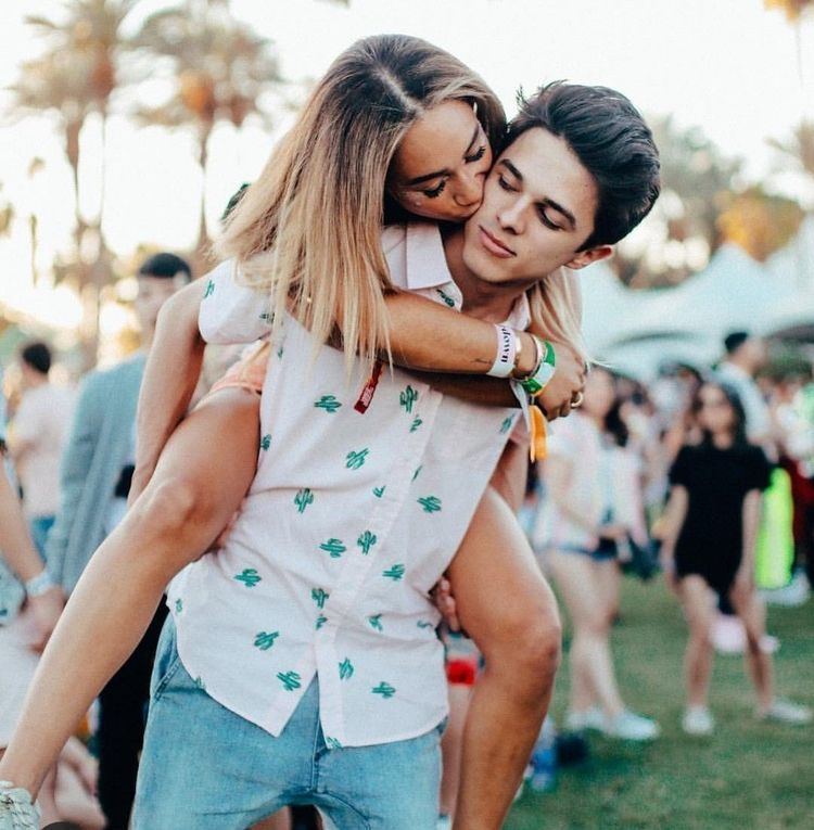 Brent Rivera receiving a kiss on the cheek from Eva Gutowski while giving her a piggy back ride