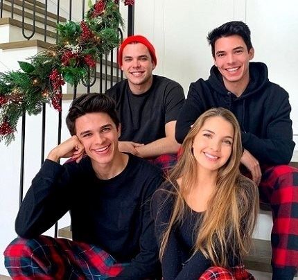 Brent Rivera smiling and sitting on the stairs beside his sister Lexie  together with his two other siblings, Brice and Blake sitting behind