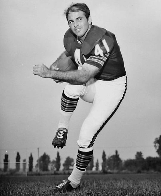 Brian Piccolo running while carrying a ball during a football game wearing a jersey numbered 41, white pants and boots