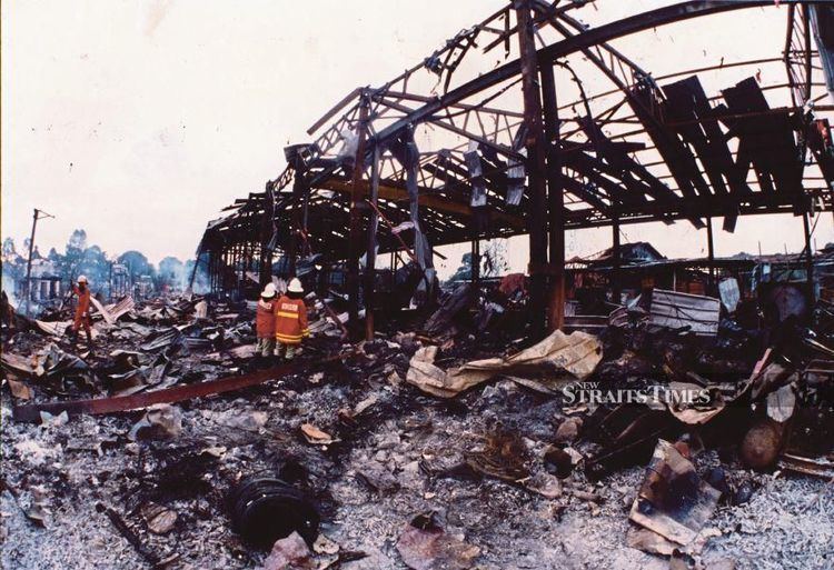 Firefighters assessing the destruction caused by the Bright Sparklers fireworks factory explosion in Sungai Buloh, Selangor, in 1991. - FILE PIX