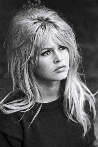 Brigitte Bardot with messy hair while wearing a black blouse