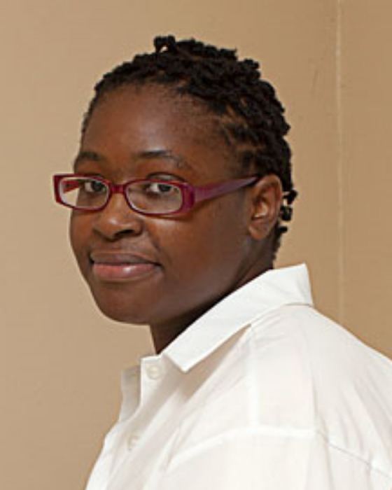 Brigitte Harris wearing a white polo shirt and a pair of eyeglasses