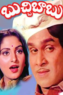 The movie poster of Buchi-Babu 1980, on top is the title written in telugu and a blue background, On the left, Jaya Prada is shocked, half mouth open looking in her left, has bindi on her forehead, black long hair wearing a red earings, orange with yellow top, on the right side is Akkineni Nageswara Rao smiling in flirty expression, looking in his left, has black hair and a thin moustache wearing a white chef toque and a maroon polo shirt.