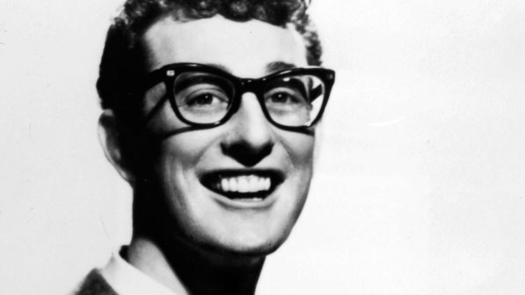 Buddy Holly with a big smile while wearing eyeglasses