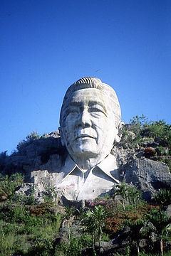 A large bust of Ferdinand Marcos into a hillside