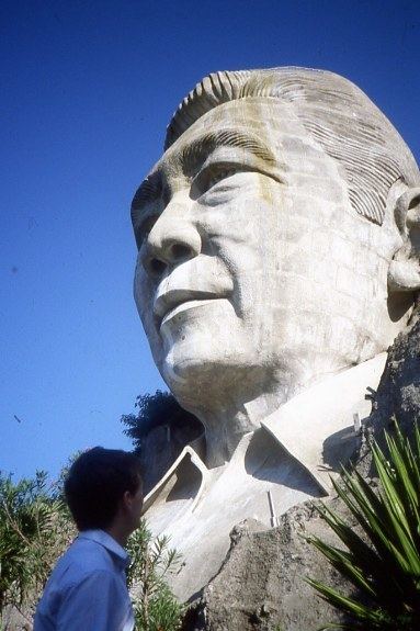 Bust of Ferdinand Marcos with a man standing