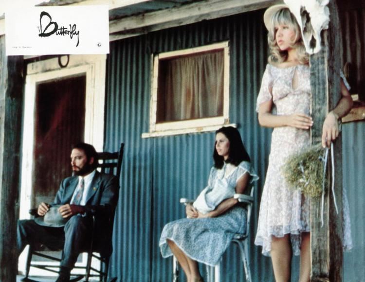 Pia Zadora looking afar together with Stacy Keach, and Ann Dane while she is holding a bouquet in a scene from the 1982 film, Butterfly