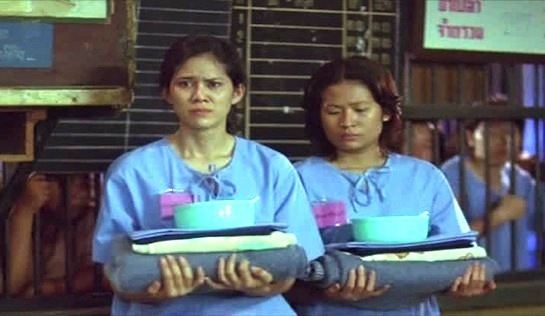 Srungsuda Lawanprasert and the woman beside her carrying bedsheets and bowl in a movie scene from the 2002 film Butterfly in Grey