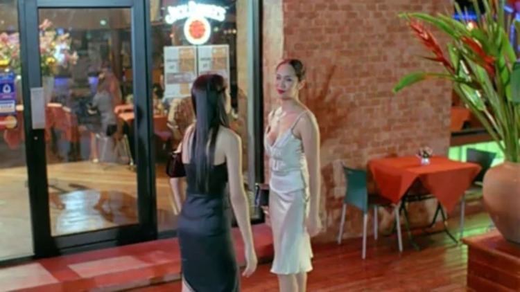 Two women talking to each other in a movie scene from the 2002 Thai drama film Butterfly in Grey