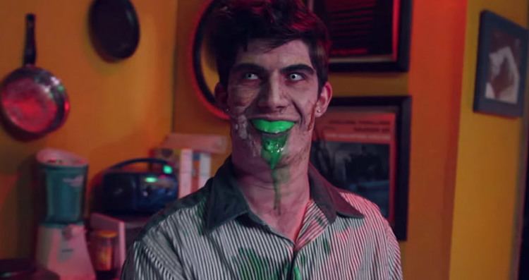 A man smiling with green liquid in his mouth in a scene from Call Girl of Cthulhu (2014 film)