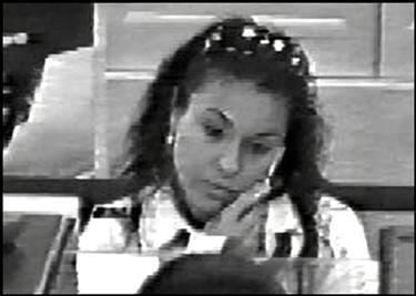 A video image from the police where Candice Rose Martinez holding a cellphone while talking to a bank teller