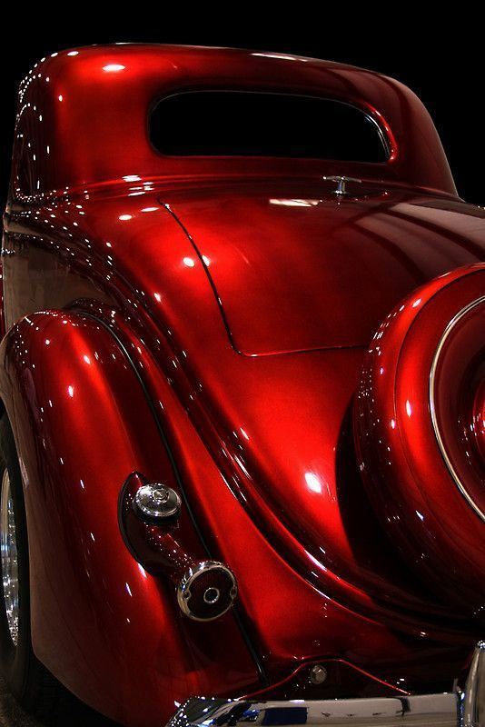 A car coated in candy apple red color with a glossy finish