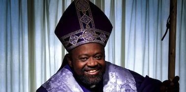 Carl Bean smiling and wearing purple pontifical vestments.
