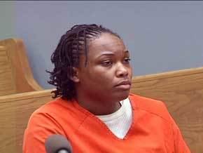 Carla Hughes at the trial court with box braid hairstyle while wearing an orange prison uniform