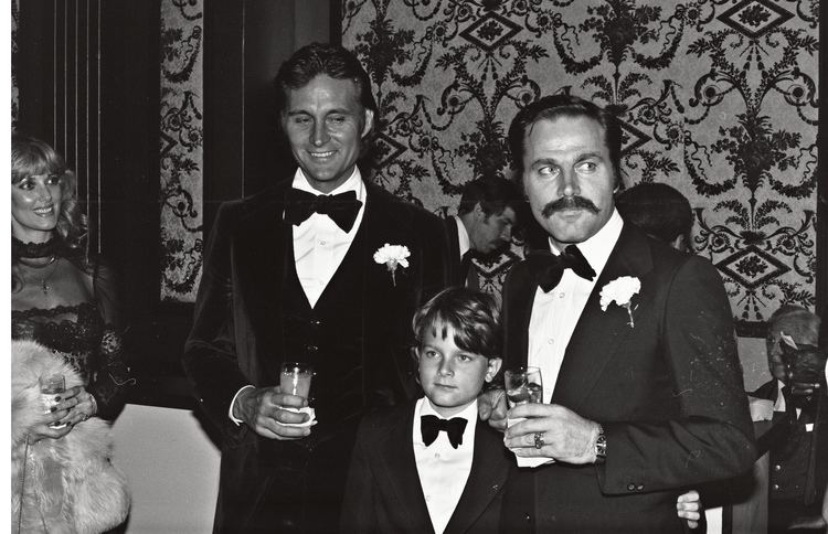 John Phillip Law smiling with Franco Nero and Carlo Gabriel Nero while wearing coat, long sleeves and bow tie