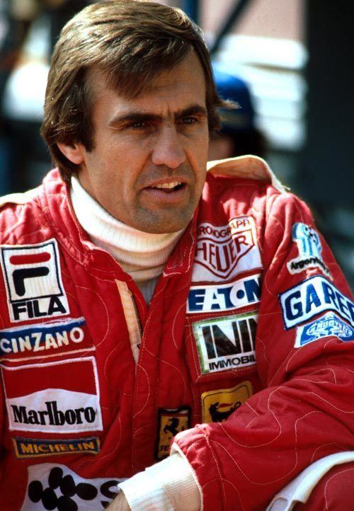 Carlos Reutemann looking afar and wearing a red racing suit