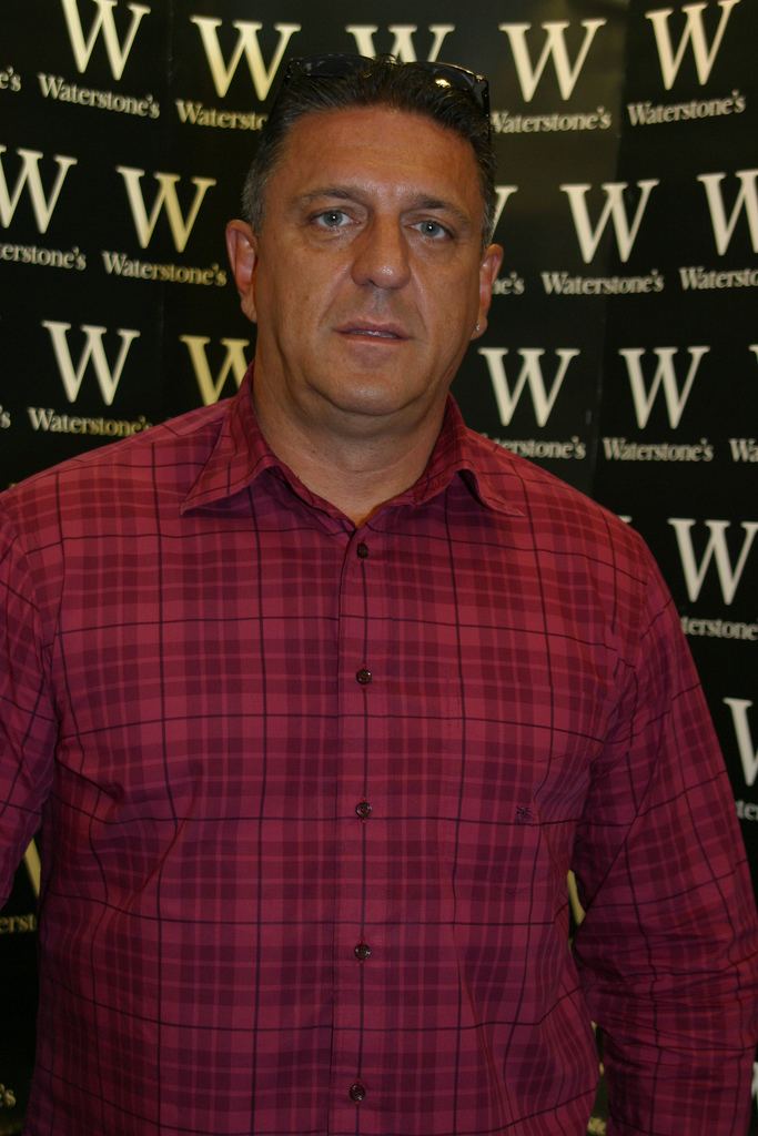 Carlton Leach with a serious face and wearing red checkered long sleeves.