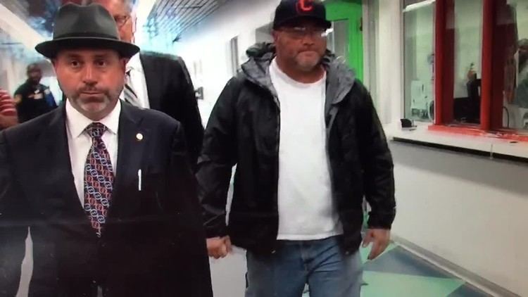 Carmine Agnello wearing cap, eyeglasses, black jacket and white t-shirt with his lawyers when he released on $100,000 bond
