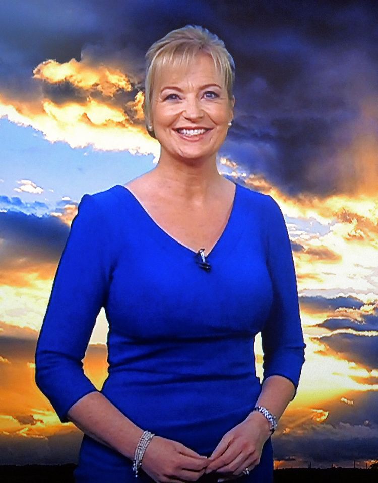 Carol Kirkwood smiling while wearing a blue dress