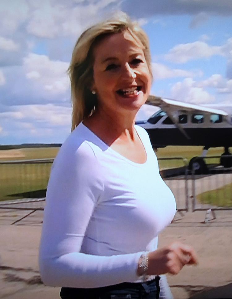 Carol Kirkwood smiling while wearing white long sleeves blouse
