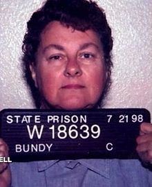 Carol M. Bundy posing for her mugshot in prison and wearing a sky blue shirt.