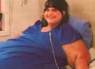 Carol Yager, one of the most severely obese people in history, smiling while lying on a hospital bed and wearing a blue shirt.
