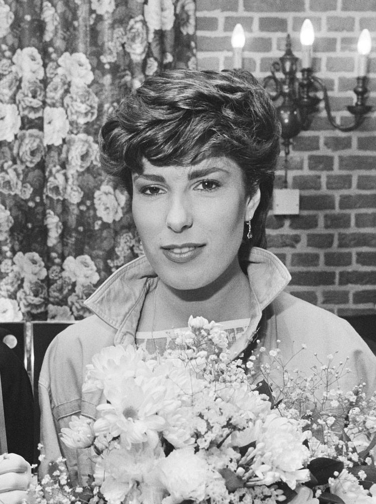 Carola Smit Carola  wearing a long-sleeved shirt and holding a bouquet of flowers(a black and white photo)