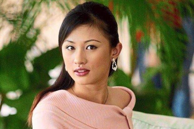 Carrie Lee Sze Kei wearing earrings, a necklace, and a pink shirt.