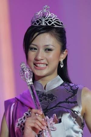 Carrie Lee Sze Kei smiling, wearing a crown, and holding a scepter during a beauty pageant.