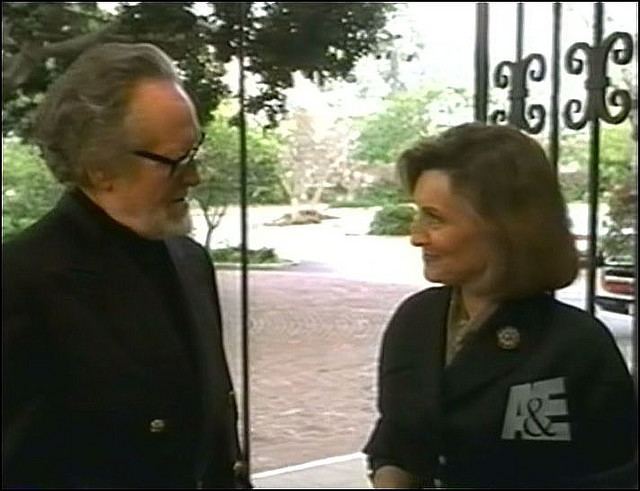 Catherine McGoohan smiling and talking to Patrick McGoohan while wearing a black coat and inner blouse