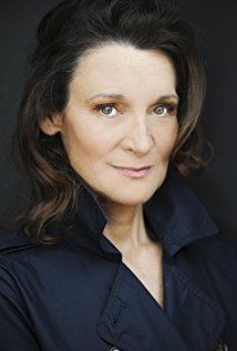 Catherine McGoohan with a tight-lipped smile while wearing a black blouse