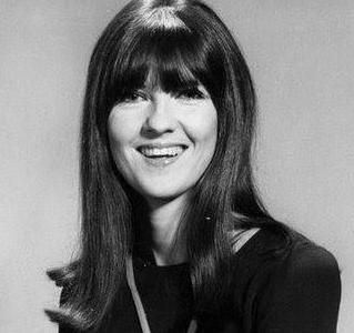 Cathy McGowan smiling with long hair and wearing a black top.