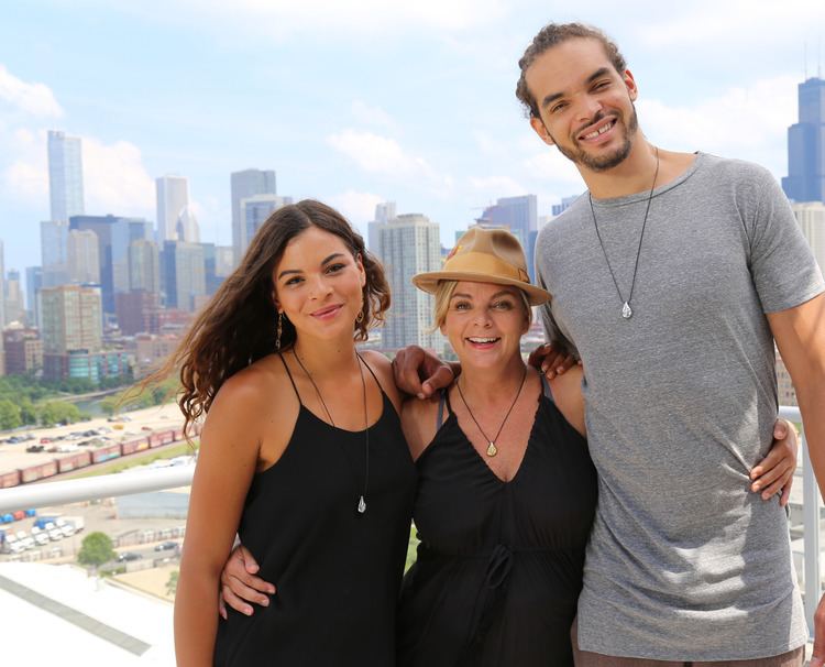 Yelena Noah smiling while wearing a black top, Cecilia Rodhe also wearing a black top and hat while Joakim Noah wearing a gray t-shirt