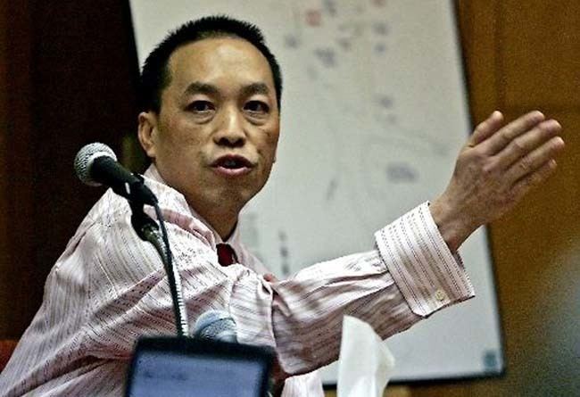 Chai Vang talking at court and wearing a long-sleeved striped formal shirt.
