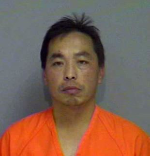 Chai Vang posing for his mugshot and wearing an orange prison inmate shirt.