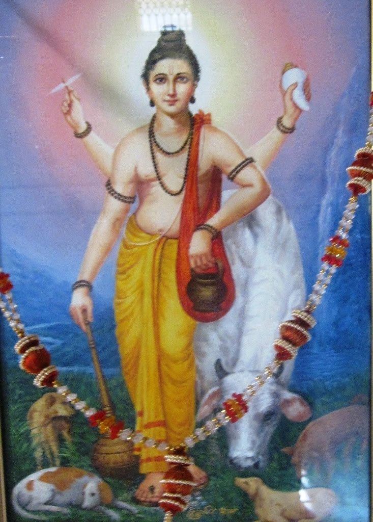 Chakradhar Swami smiling while carrying a red bag and wearing a yellow skirt, necklace, earrings, and bracelets