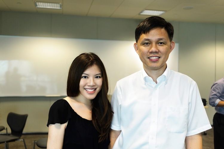 Chan Chun Sing smiling and wearing white polo while the woman beside him is also smiling and wearing a black blouse