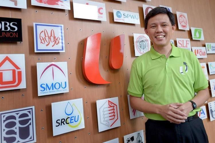 Chan Chun Sing smiling while wearing a green polo shirt and black pants