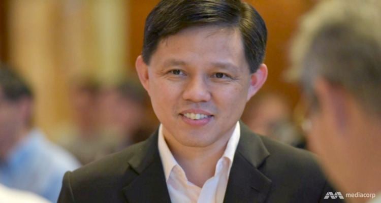 Chan Chun Sing smiling while wearing a black coat and white long sleeves