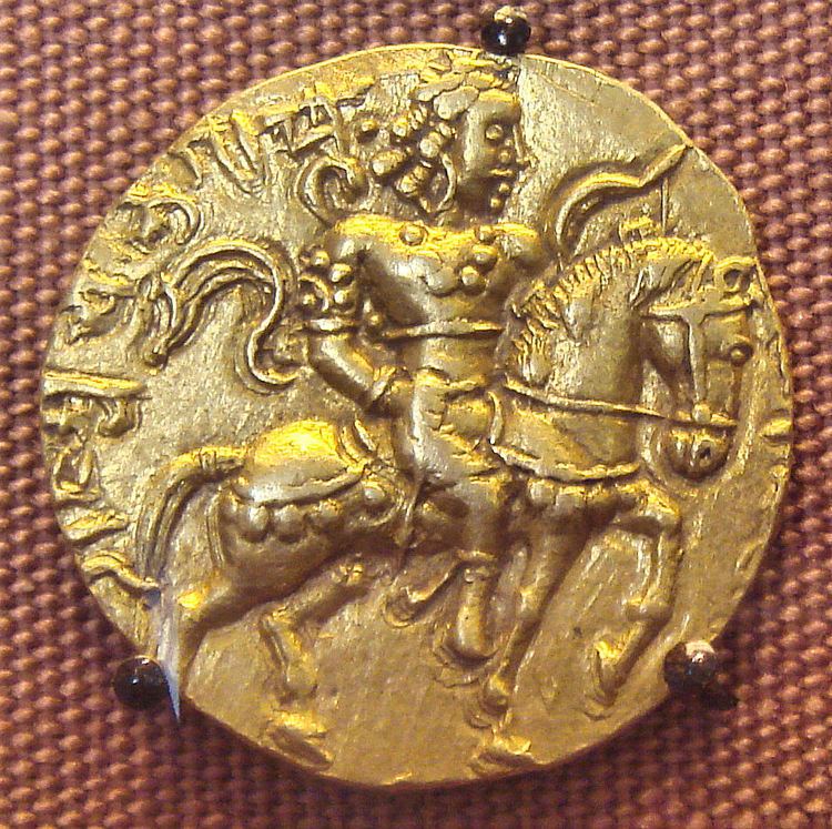 An 8-gram gold coin featuring Chandragupta II astride a caparisoned horse with a bow in his left hand.