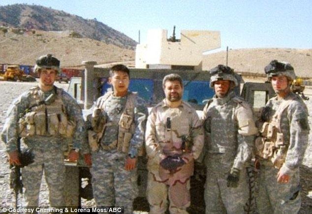 At the back of the truck, the man on the left is serious, has a beard and, mustache, and his right hand holding a rifle wears a wristwatch in his left hand, load-bearing equipment, his army uniform and cap, 2nd from left, a man is serious, has black hair, wears a wristwatch on his left hand, a load bearing equipment and his army uniform, 3rd from left is man, has black hair, a beard, and a mustache, both hands holding each other, wears his load-bearing equipment and his army uniform, 2nd from left is Channing Moss, serious, left hand wearing gloves, shoulder pads, and his army uniform and cap, on right a man is serious, wear a load bearing equipment, and a military uniform and cap.