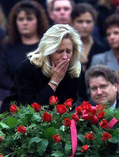 Sheri Burlingame kissing the casket of her husband Capt. Charles Frank Burlingame during the funeral service and wearing a black blouse