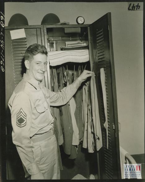 Charles E. Kelly Tech Sgt Charles E Kelly at wall locker in his room at