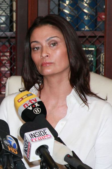 Charlotte Lewis with strict face and wearing a white polo shirt during an interview.