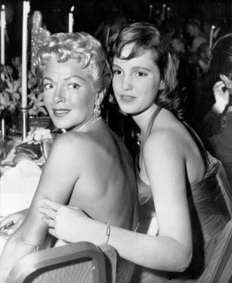 Lana Turner and Cheryl Crane while smiling and wearing dress