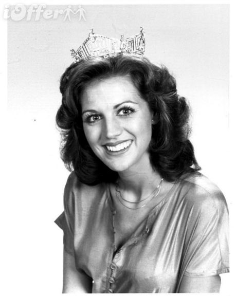 Cheryl Prewitt smiling while wearing a crown, necklace, and blouse