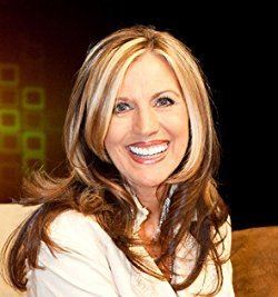 Cheryl Prewitt smiling while wearing a white blouse